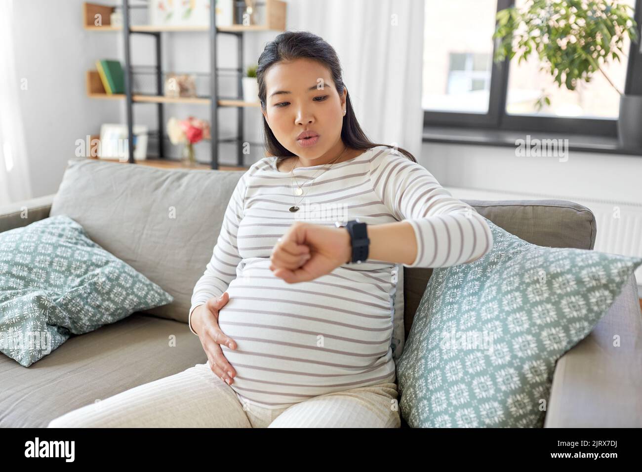donna incinta che ha contrazioni di lavoro a casa Foto Stock