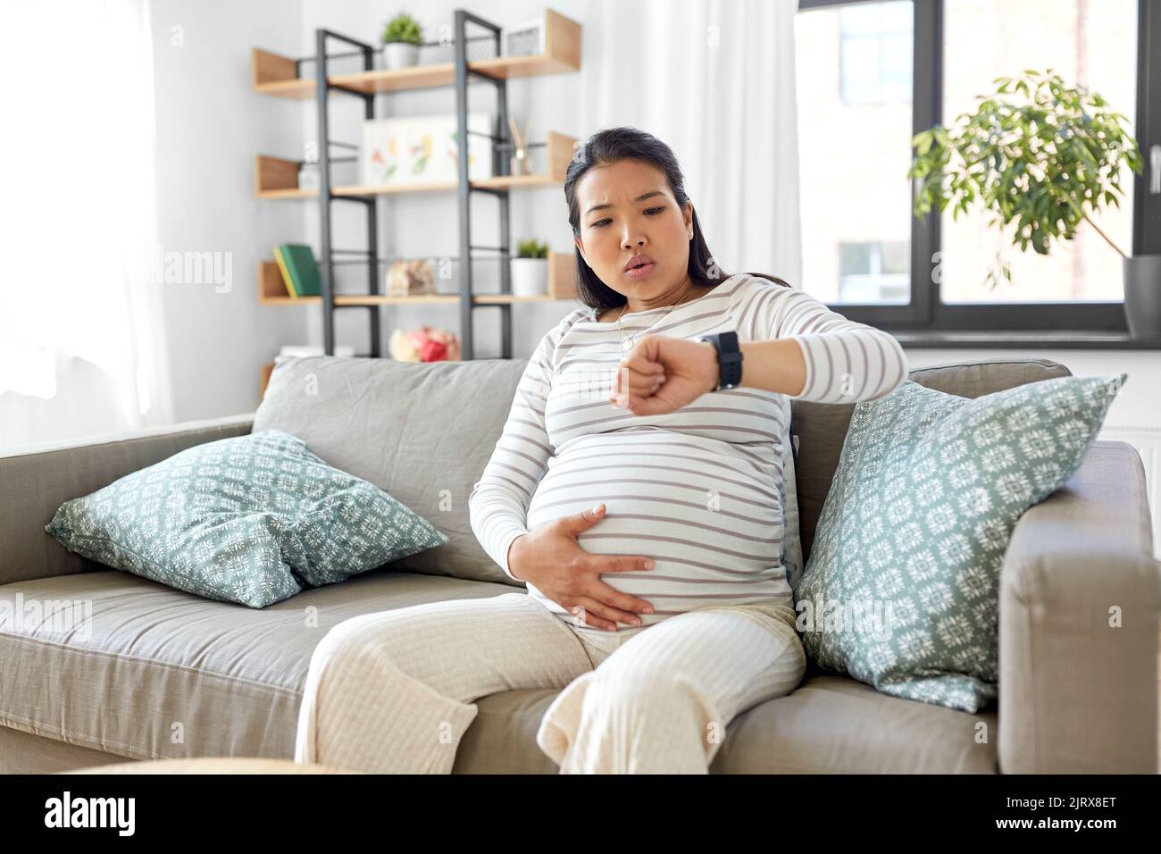 donna incinta che ha contrazioni di lavoro a casa Foto Stock