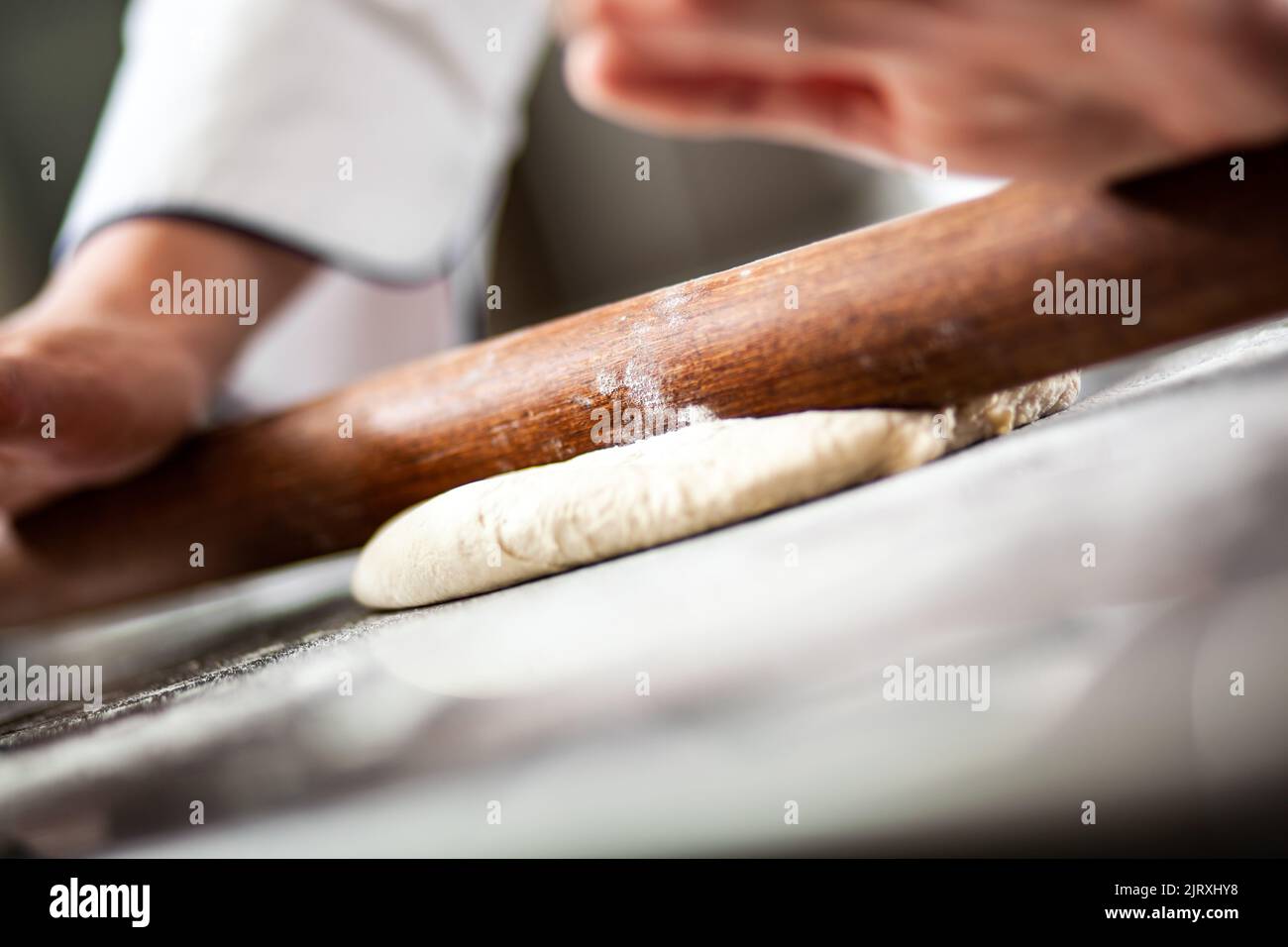 Chef stendendo l'impasto in cucina, primo piano Foto Stock