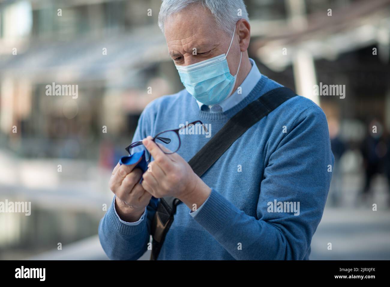 Il vecchio uomo pulisce i suoi occhiali con panni per la pulizia Foto stock  - Alamy