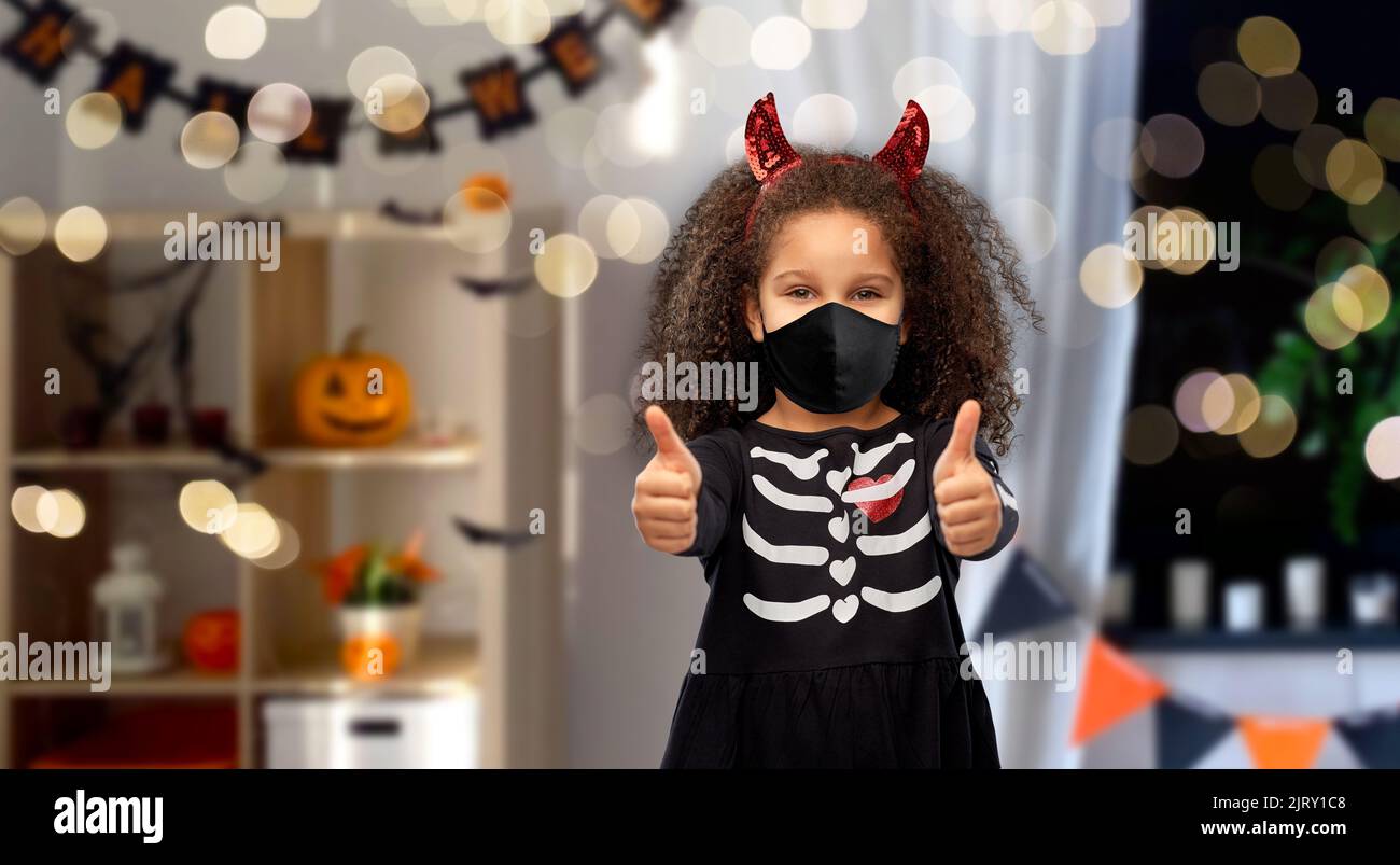 ragazza in maschera nera e costume di halloween del diavolo Foto Stock