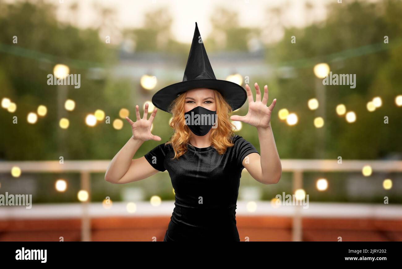donna in maschera nera e costume di halloween della strega Foto Stock