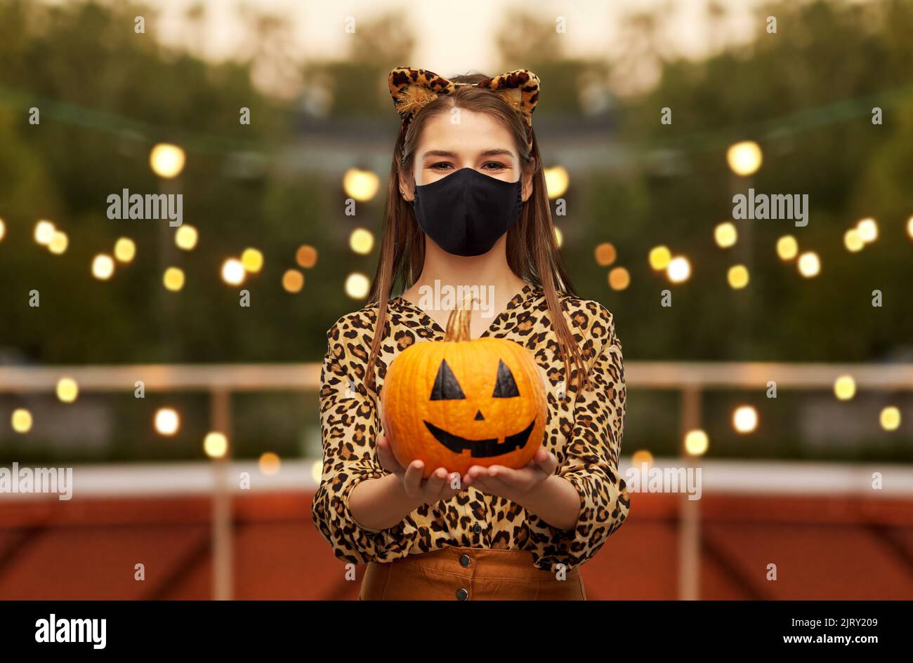 donna in costume di halloween e maschera con zucca Foto Stock