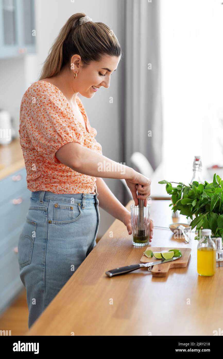 donna che fa cocktail bevande in cucina a casa Foto Stock