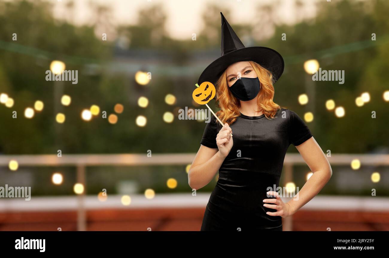 donna in maschera nera e costume di halloween della strega Foto Stock