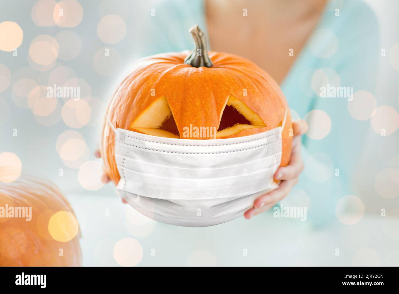 primo piano della donna che tiene la zucca in maschera Foto Stock