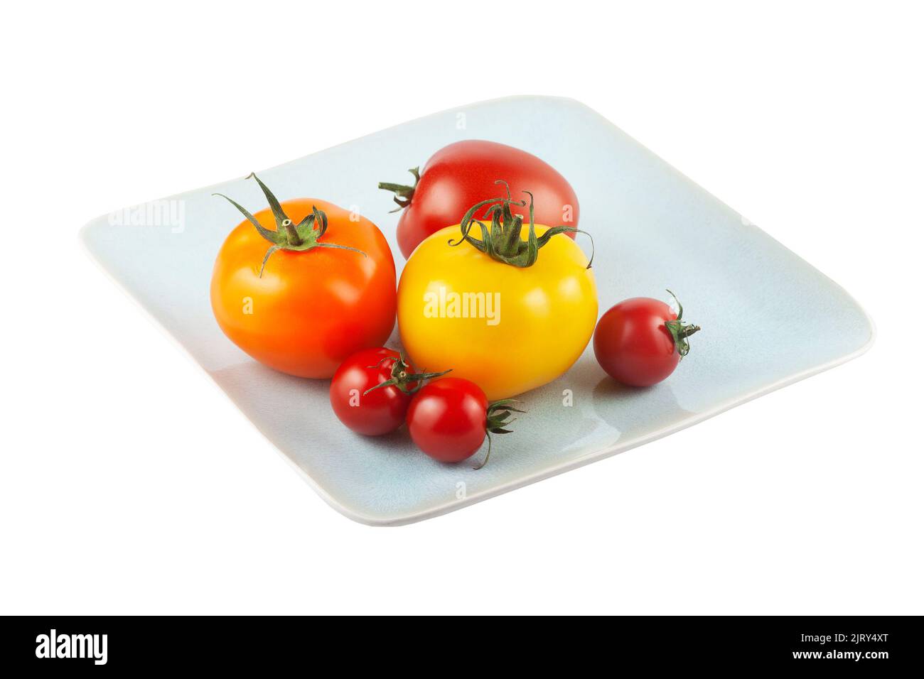 Sei pomodori freschi biologici su un piatto con fondo bianco. Varietà di misure e colori: Rosso, giallo e arancione Foto Stock