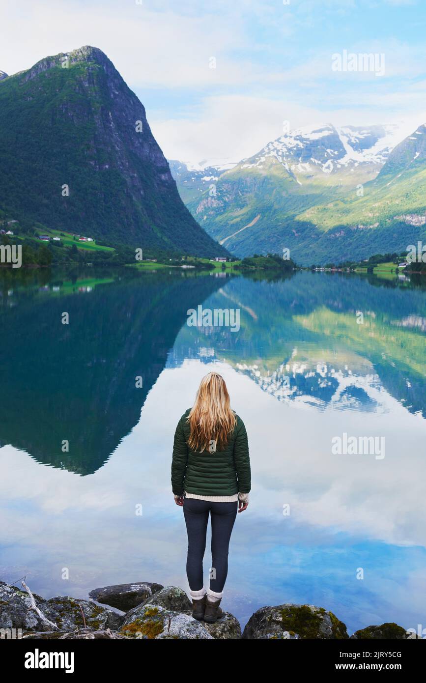 Avventura donna godendo la vista del maestoso lago di montagna esplorare viaggio scoprire la bella terra Foto Stock