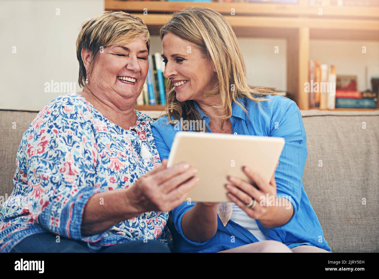 Guarda mamma, tutti stanno passando al digitale in questi giorni. Una donna matura e la madre anziana utilizzano un tablet digitale insieme a casa. Foto Stock