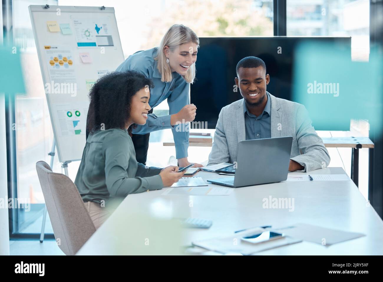 Il team di contabilità aziendale è felice della crescita finanziaria e della strategia aziendale in un incontro in ufficio. Colleghi entusiasti che lavorano su un notebook Foto Stock