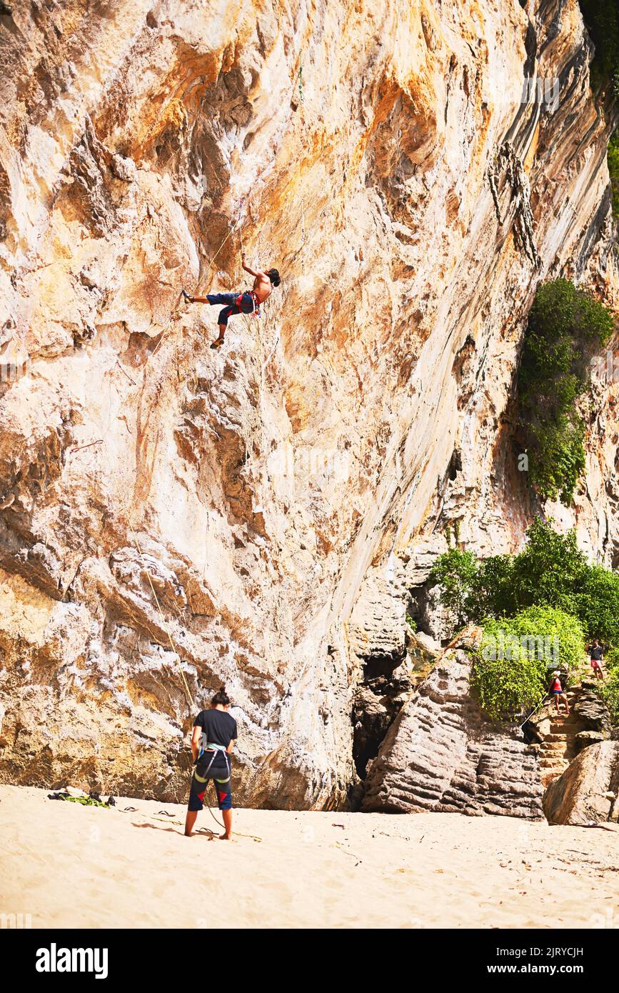 Condividono uno spirito avventuroso: Due giovani si arrampicano su roccia in una giornata di sole. Foto Stock