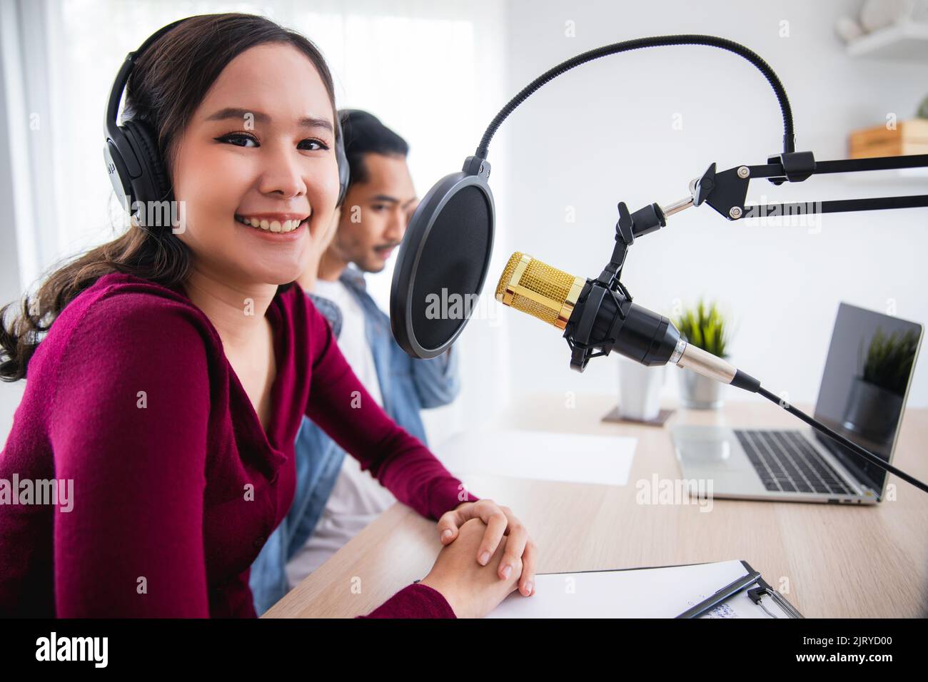 Giovane donna e uomo asiatico che registra e lavora come dj e podcast, trasmettendo il concetto di home studio Foto Stock