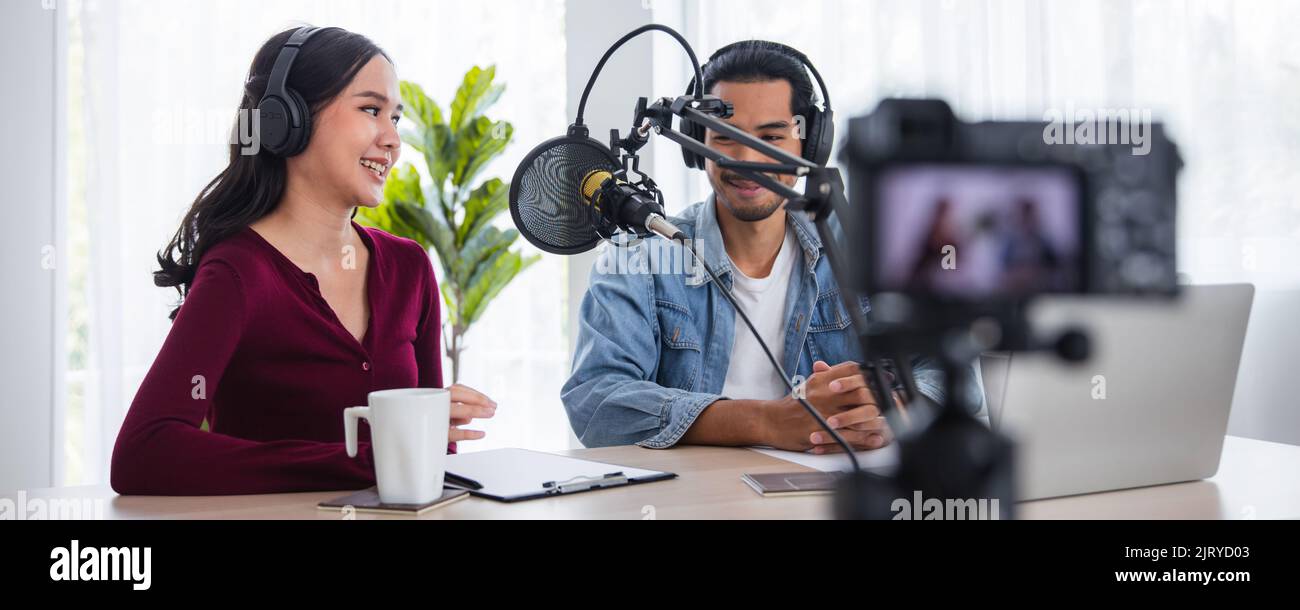 Giovane donna e uomo asiatico che registra e lavora come dj e podcast, trasmettendo il concetto di home studio Foto Stock