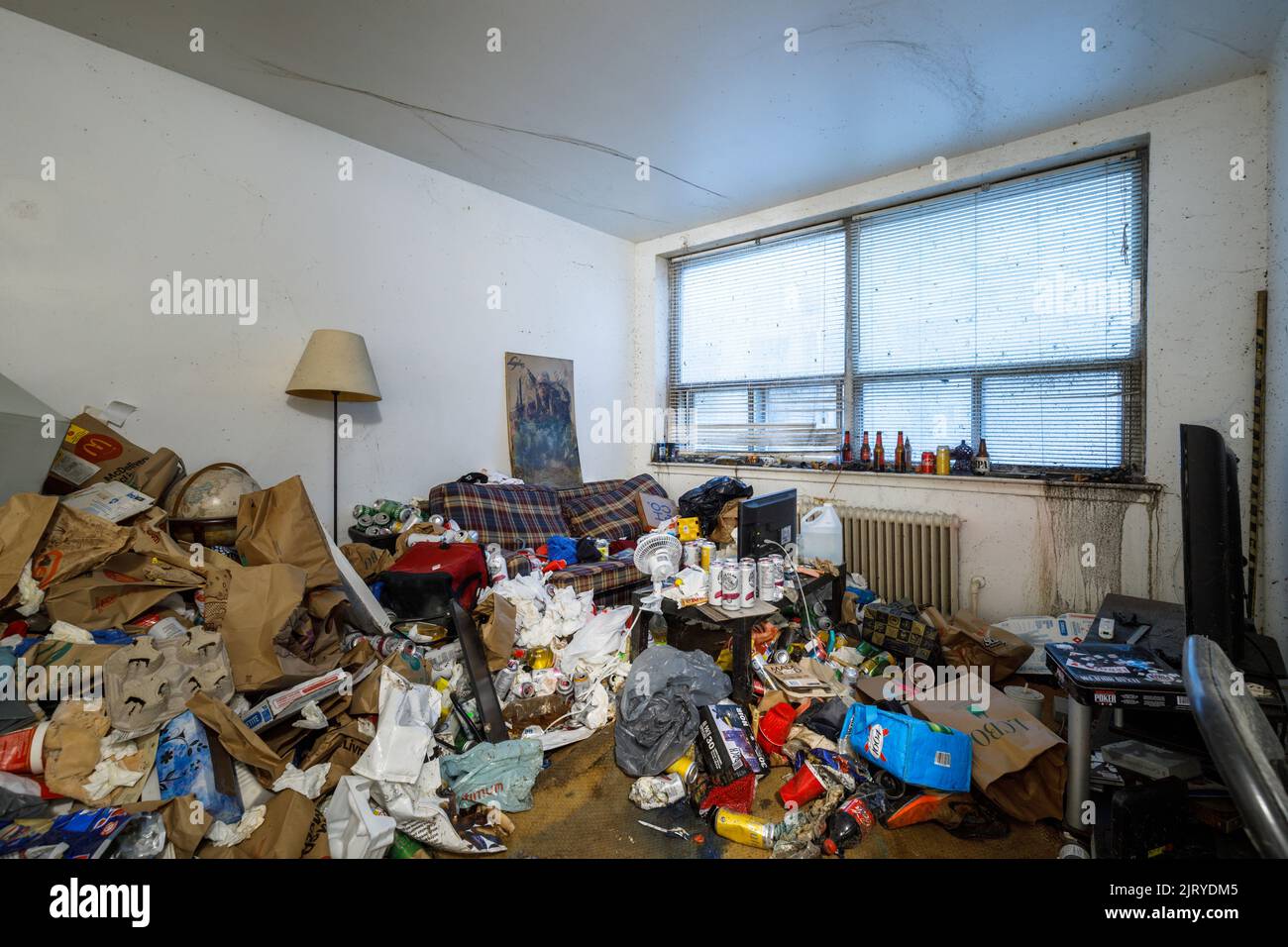 Un soggiorno appartamento sporco con un sacco di ammasso all'interno di un appartamento di un hoarder. Questo edificio è stato da allora demolito Foto Stock