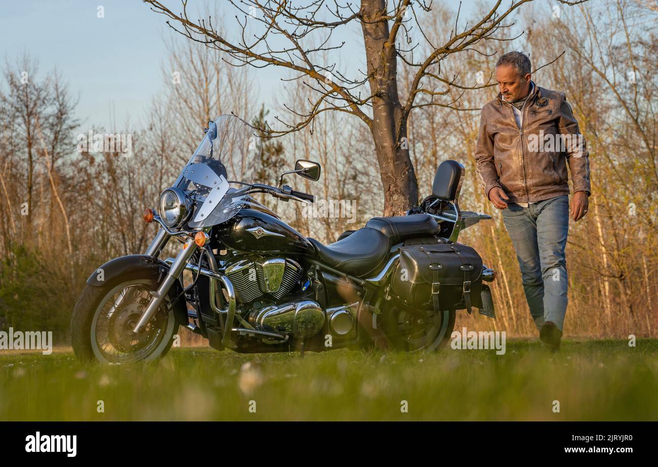 Uomo in giacca di pelle gira intorno alla sua moto, Karlsruhe, Germania Foto Stock