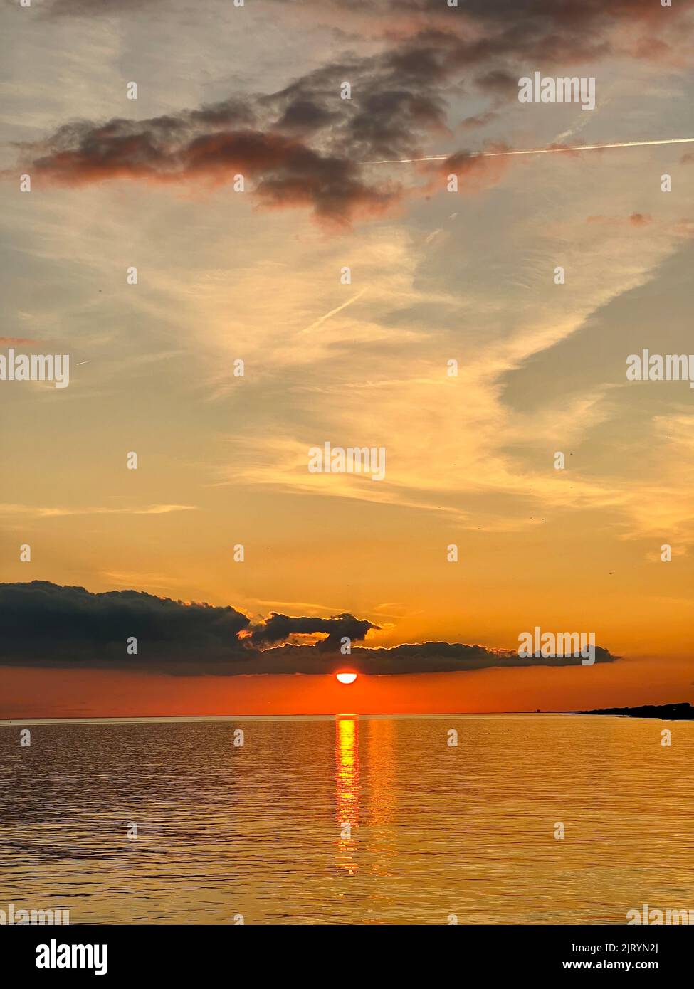 Riflessi di un tramonto in una calda e tranquilla serata estiva Foto Stock