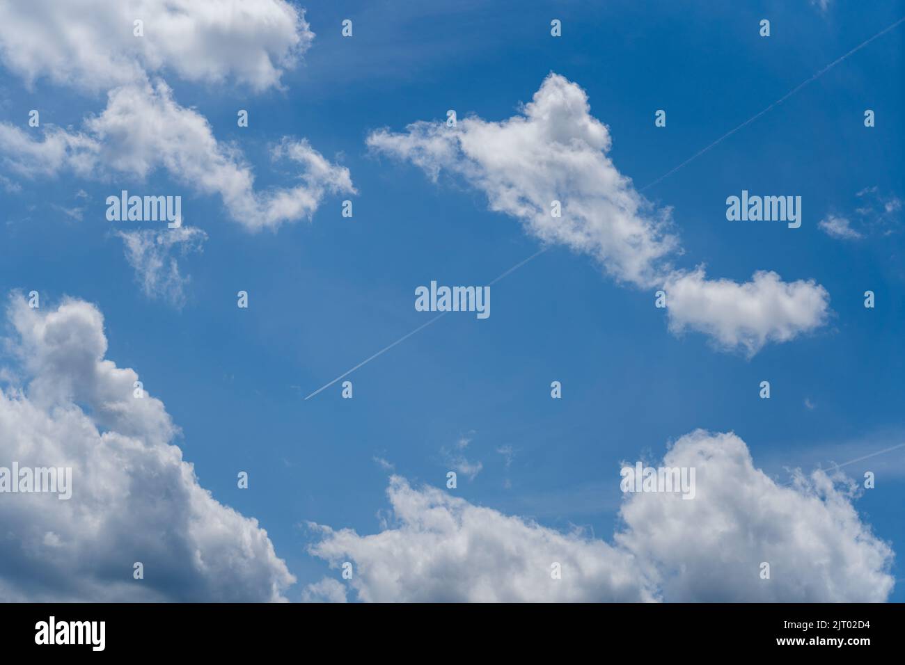 Un aereo in un cielo blu con alcune nuvole bianche Foto Stock