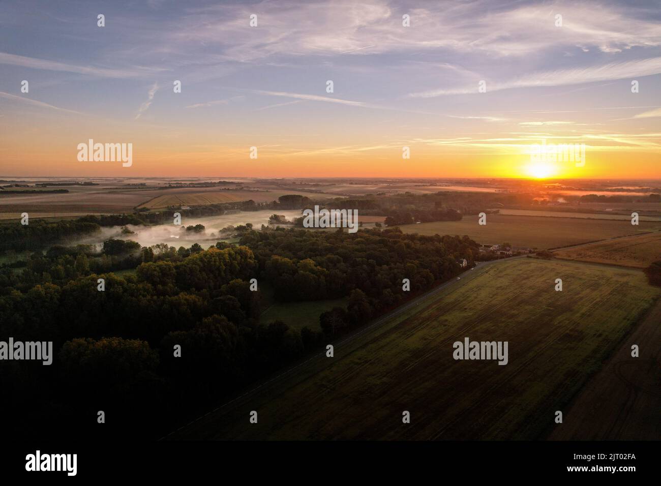 Vista aerea dell'alba sulla città di Chateauroux, con nebbia intorno all'albero, cielo arancione e cielo blu Foto Stock