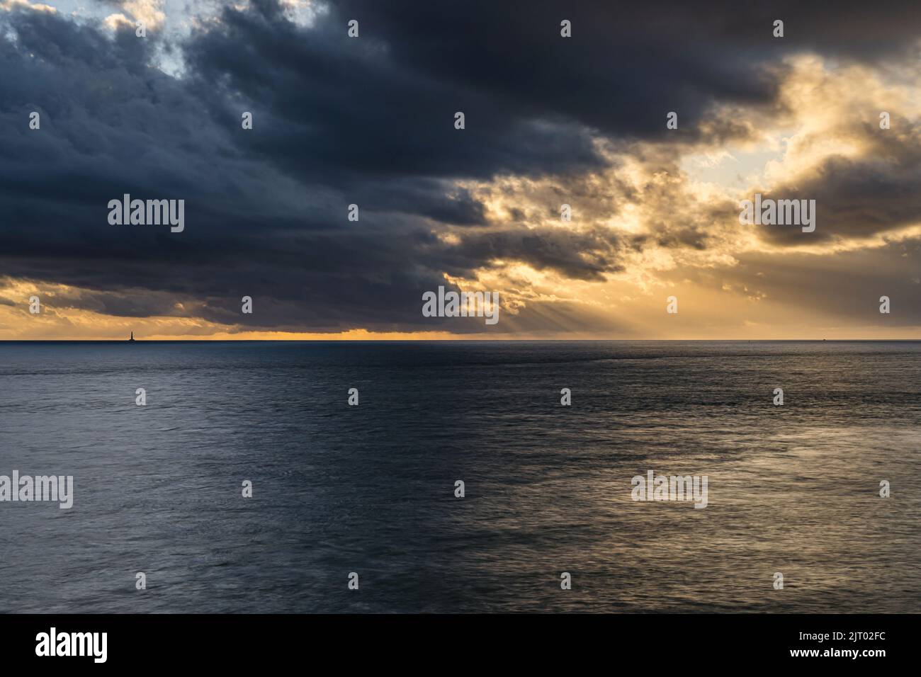 Il sole si raggi attraverso le nuvole sull'oceano, vicino al faro di Cordouan, Royan, Francia Foto Stock