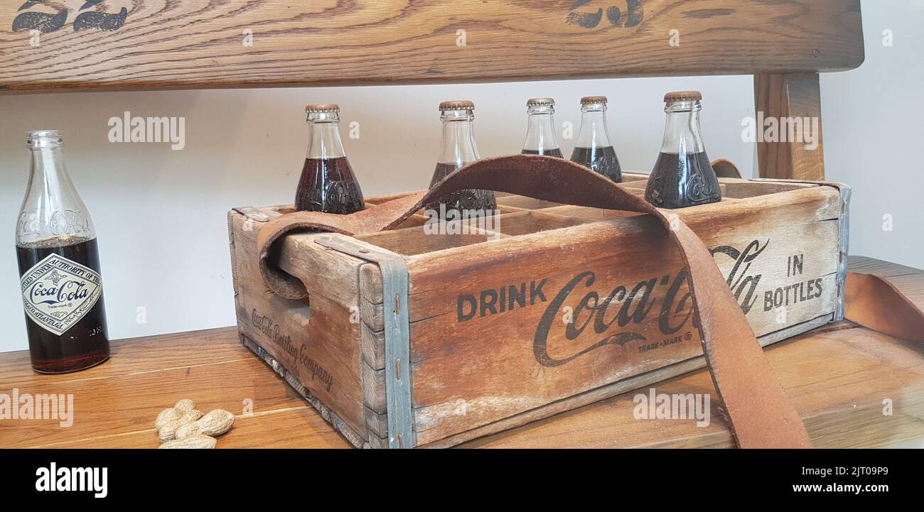 Un primo piano di bottiglie di Coca Coca Cola su un asse di legno Foto Stock