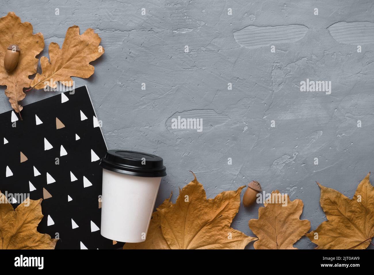 Composizione autunnale. Caffè da asporto, notebook, cuffie con foglie autunnali. Disposizione piatta, vista dall'alto, spazio di copia Foto Stock