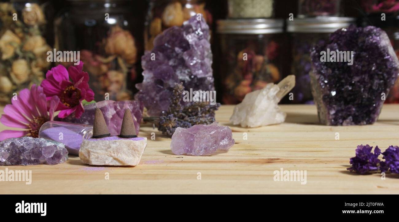 Cristalli di Ametista con fiori e coni di incenso sull'altare di meditazione Foto Stock