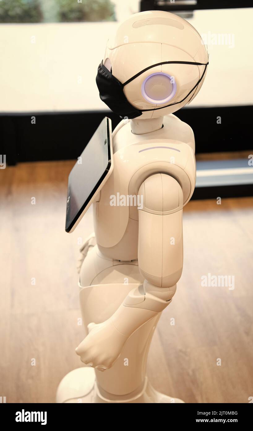 futuristico robot assistente tecnologia innovativa in maschera protettiva Foto Stock