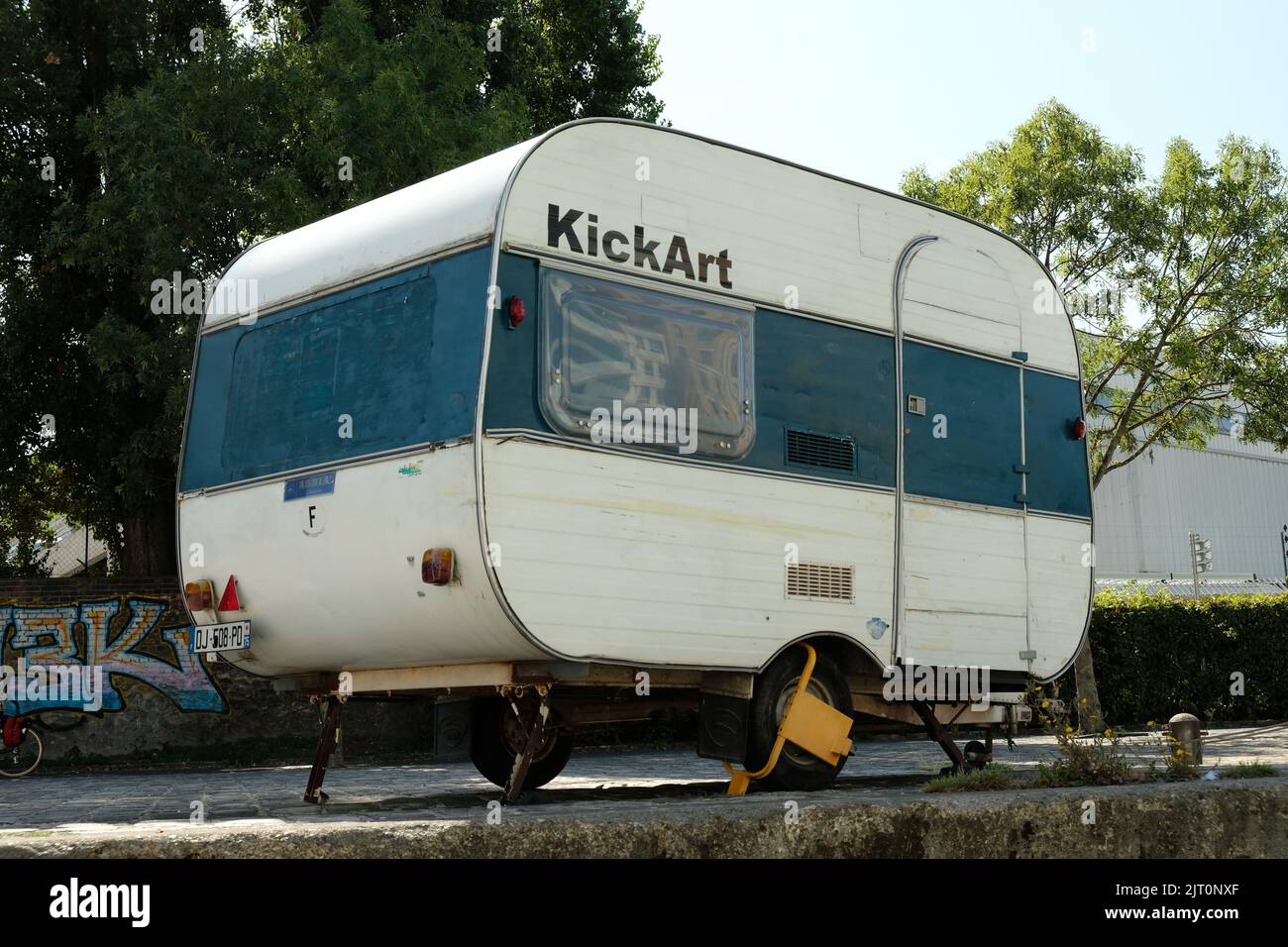 Un rimorchio sulla strada con alberi verdi sullo sfondo. Bassin de la Villette, Parigi. Foto Stock