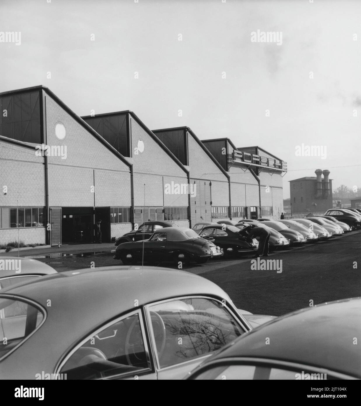 Storia Porsche. Una rara vista della fabbrica di automobili Porsche a Stoccarda in Germania negli anni '1950s. Nei locali della fabbrica le vetture Porsche sono visibili in diverse fasi di produzione. L'emblema di Porsche è visto nell'edificio della fabbrica. 1951. Foto Stock