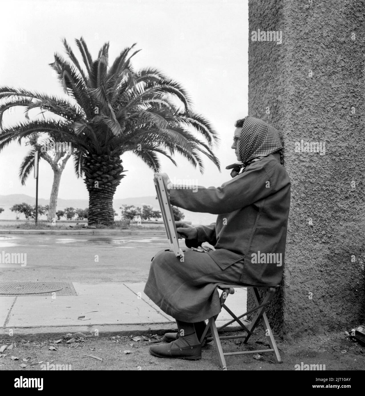 Negli anni '1950s. Una donna siede in strada e dipinge qualcosa. Fiume francese 1951 Conard Ref 1666 Foto Stock