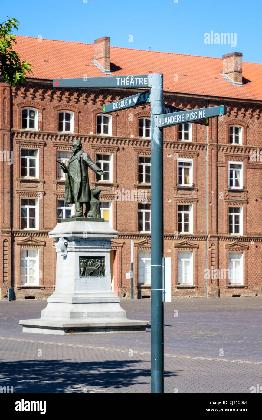 Statua di Godin e segnaletica che mostra i diversi edifici della Familistère, un complesso di case tipo falangeria a Guise, Francia. Foto Stock