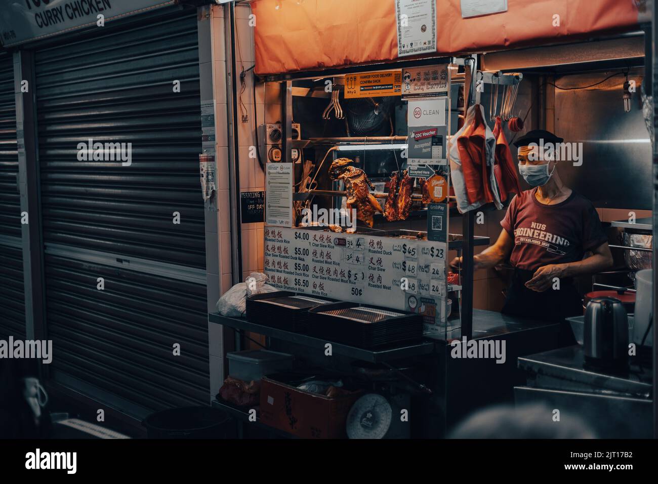 Un uomo che cucinava al locale di Street food Foto Stock