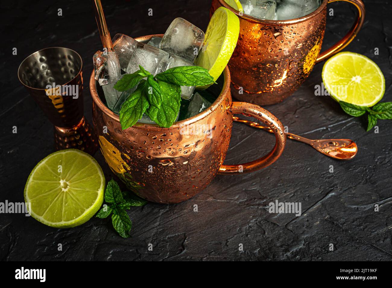 Cocktail Mule ghiacciato in una tazza di rame con birra allo zenzero, vodka, lime e menta. Sfondo grigio. Foto Stock