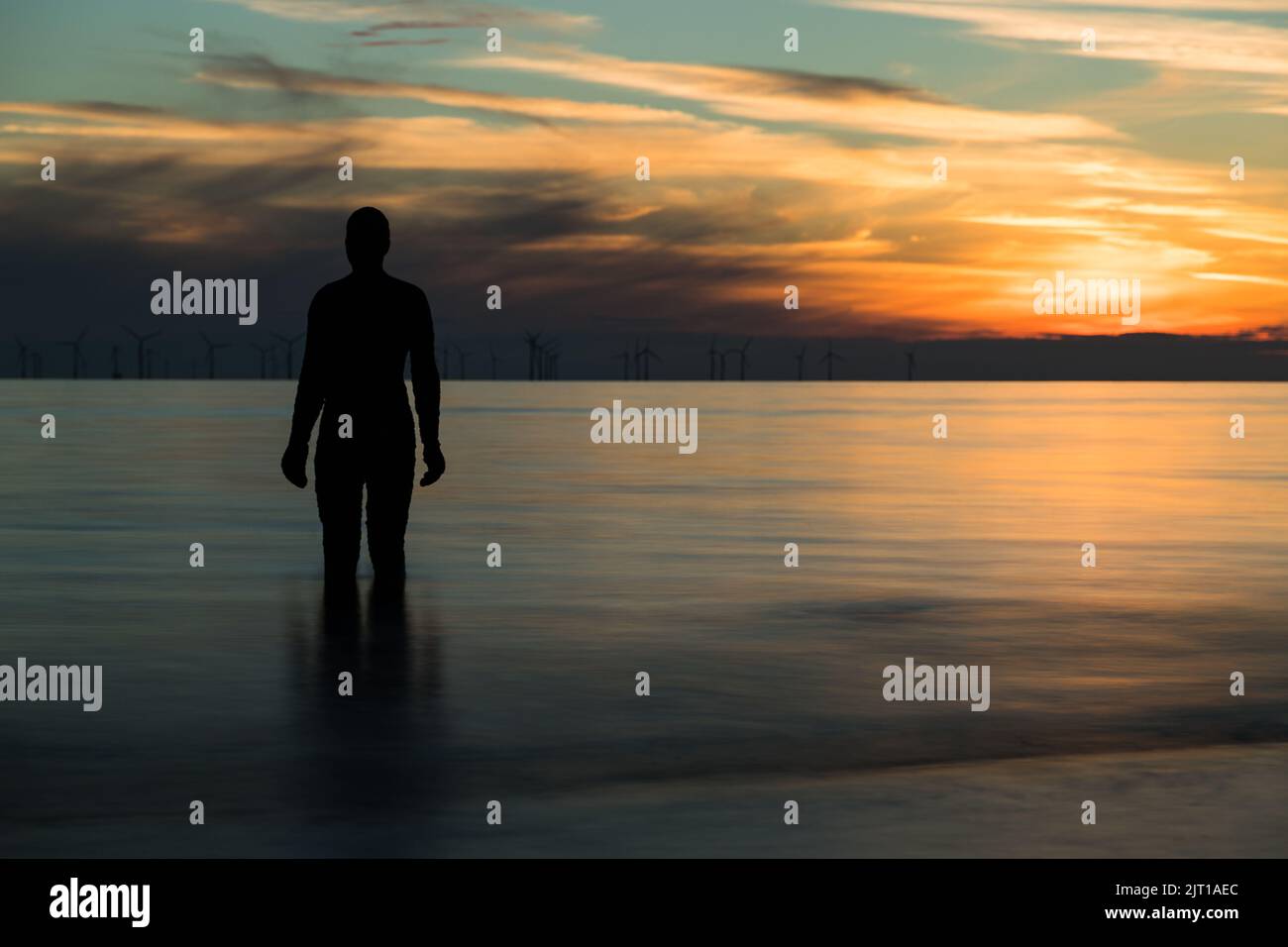 Lungo essopure di un uomo di ferro che guarda fuori al mare a Crosby vicino Liverpool, preso il 22nd agosto 2022. Foto Stock