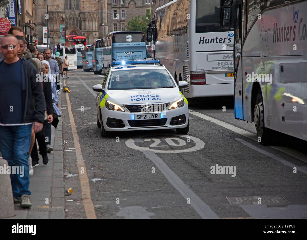 Centro di Edimburgo, Scozia, Regno Unito. 27th ago, 2022. Affollato fine settimana dell'Edinburgh Festival Fringe, temperatura di 18 gradi, ammira le strade affollate da persone di ogni tipo godendo dell'atmosfera vibrante. Nella foto: Auto di polizia veloce con luci blu lampeggianti sul lato sbagliato di Gerge 1V Bridge a causa del traffico pesante tatuaggio Credit: Arch White/Alamy Live News Foto Stock