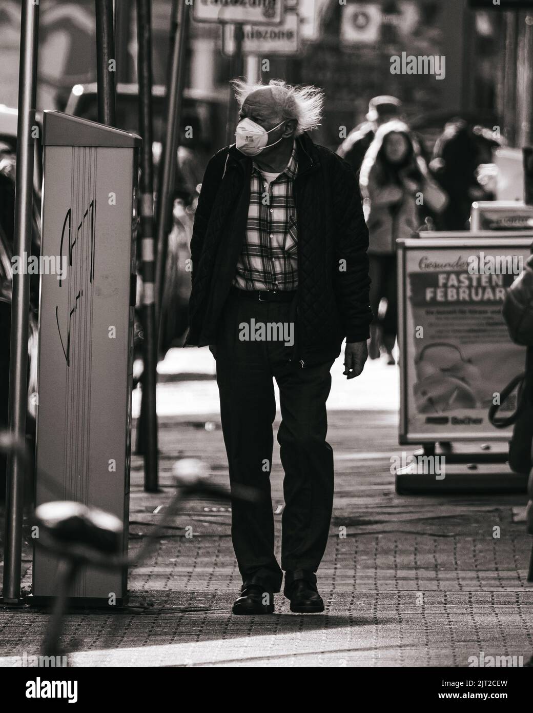 Una vita urbana in città con un vecchio sulla strada Foto Stock