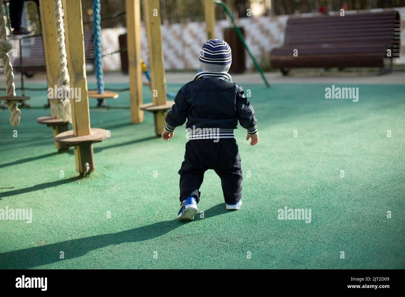 Bambino sulla strada. Bambini nel parco giochi. Il ragazzino cammina da solo. Bambino da dietro. Foto Stock