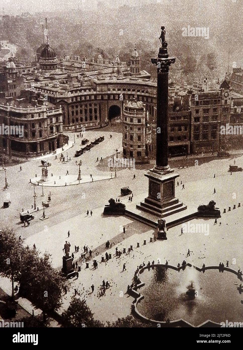 VECCHIA LONDRA - Una fotografia molto antica di Trafalgar Square e della colonna di Nelson, Londra presa dalla cima di St Martin nella chiesa di campo con smog (fumo e nebbia nell'atmosfera), traffico scarso e poche persone in evidenza. Si possono vedere persone che nutrono i piccioni nell'angolo in basso a sinistra Foto Stock