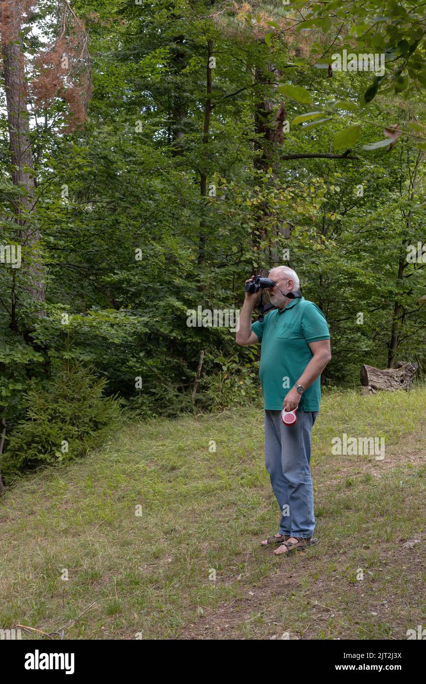 l'uomo guarda la natura con il binocolo Foto Stock
