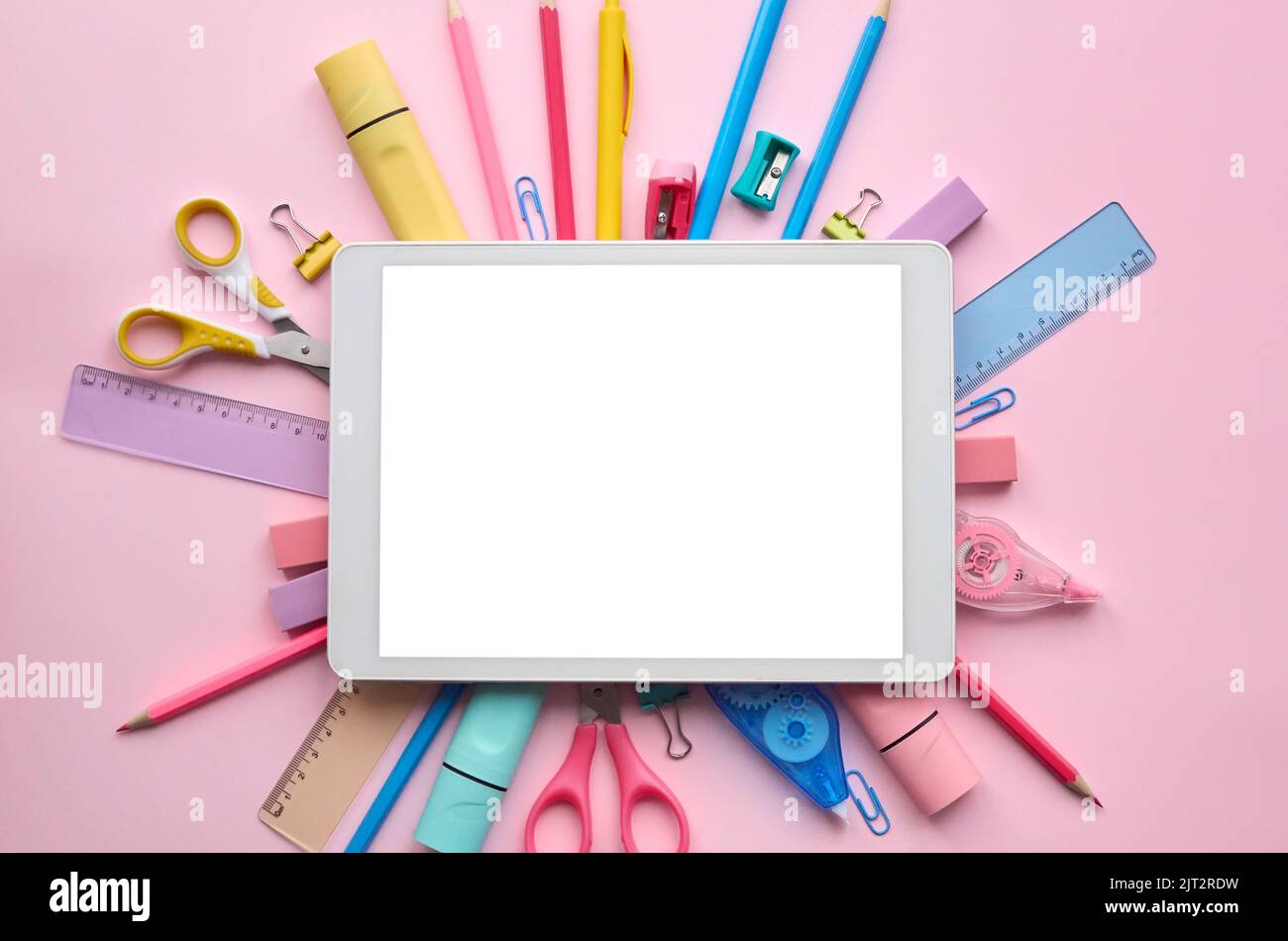 Schermo modello per tablet digitale su sfondo rosa cartoleria scolastica. Foto Stock