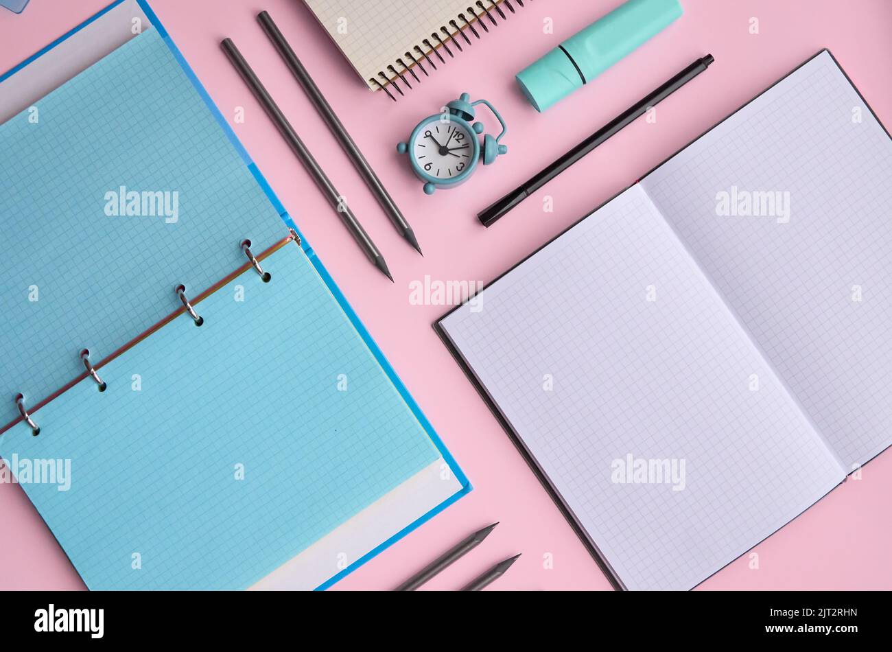 I notebook aperti e la scuola forniscono gli accessori dei prodotti su sfondo pastello. Foto Stock