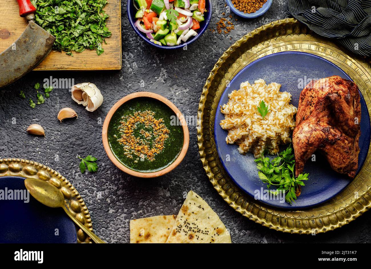 Cucina araba; piatto egiziano Molokhya o Molokhia con riso, pollo, pane pita, insalata verde orientale e aglio fritto croccante. Foto Stock