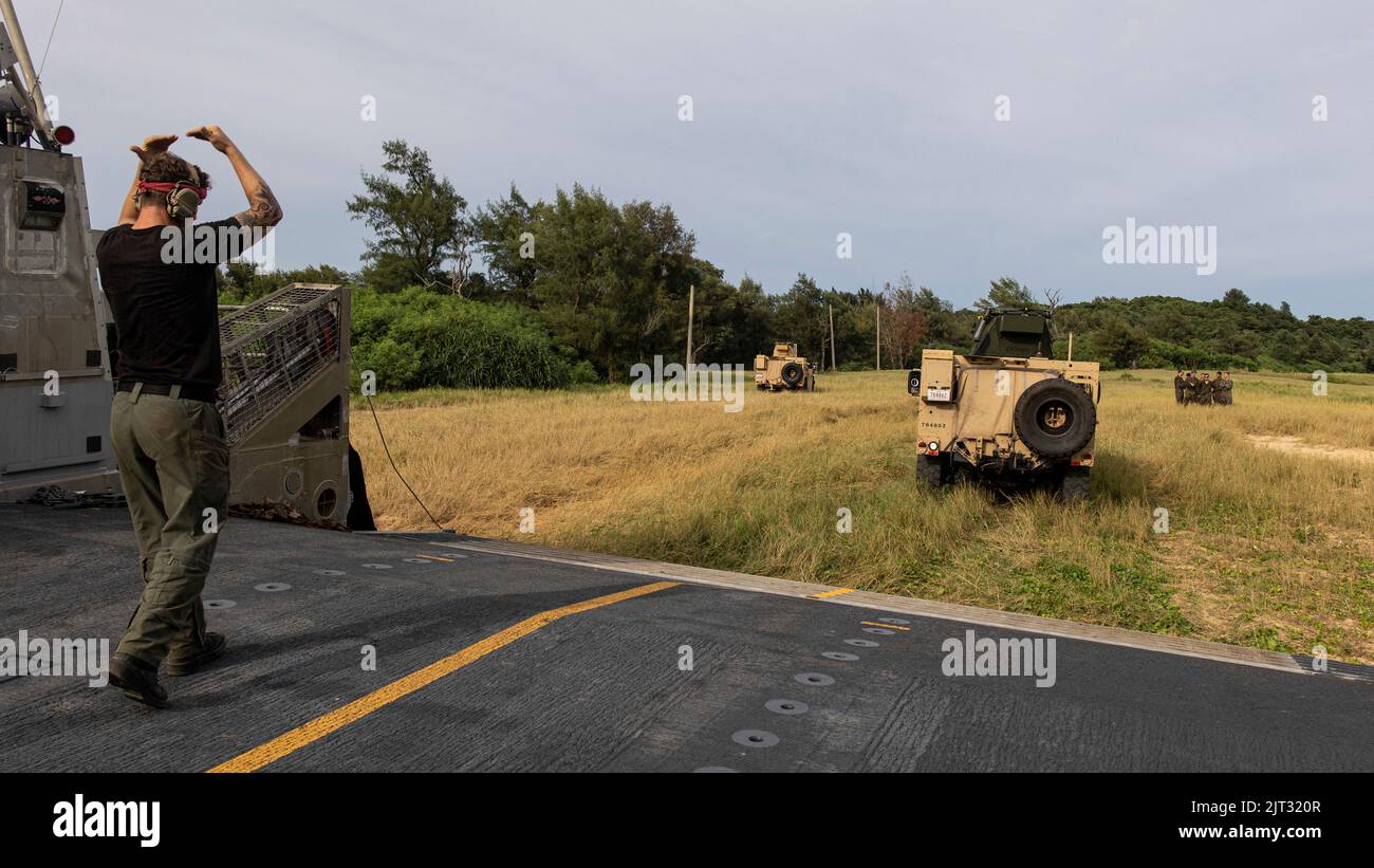 U.S. Navy Boatswain's Mate 2nd Class Kameron Thompson, assegnato alla USS New Orleans (LPD 18), segnala un veicolo tattico leggero congiunto del corpo dei Marine degli Stati Uniti con il Battaglione Landing Team 2/5, 31st Marine Expeditionary Unit, durante un'estrazione a Kin Blue, Okinawa, 21 agosto 2022. Il team combinato anti-armature fornisce funzionalità di blocco e isolamento e anti-armature alle aziende di linea. Il MEU 31st opera a bordo delle navi del Gruppo Amphibious Ready di Tripoli nell'area di attività flotta 7th per migliorare l'interoperabilità con alleati e partner e servire come pronta forza di risposta da difendere Foto Stock