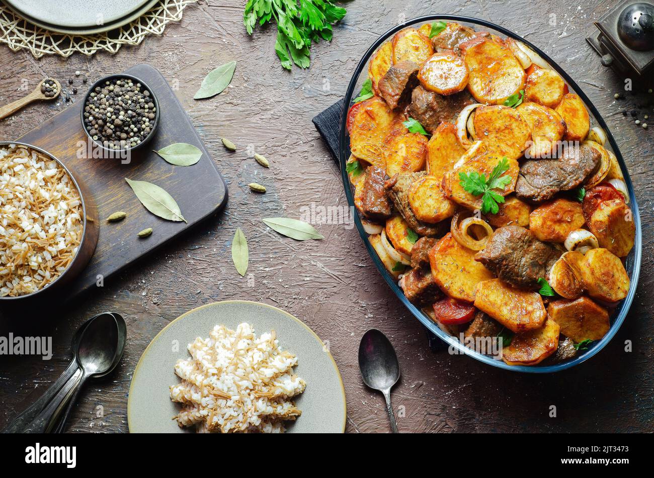 Cucina araba; piatto orientale egiziano 'patate al forno con pezzi di vitello' servito con riso tradizionale con vermicelli. Vista dall'alto con spazio di copia. Foto Stock