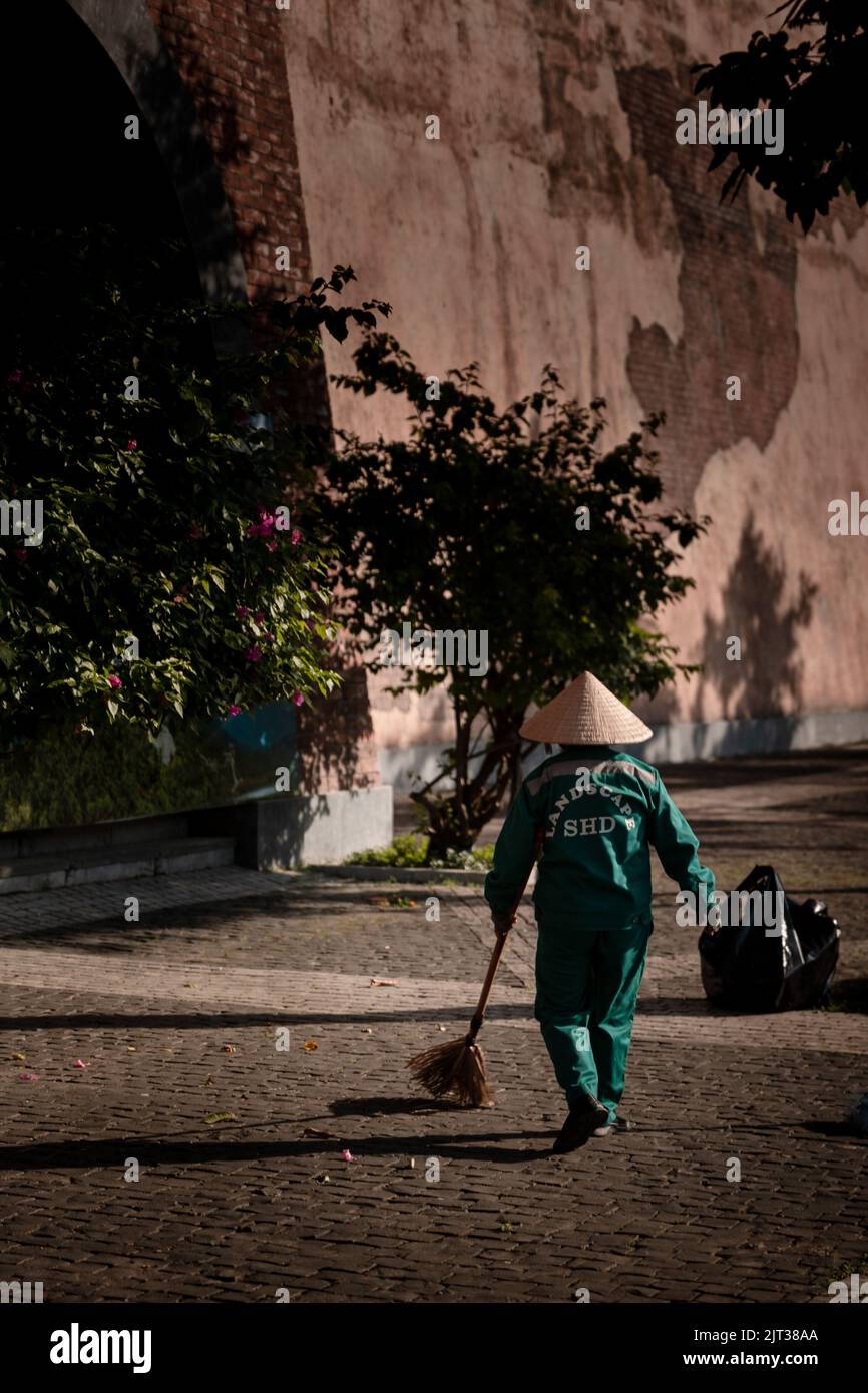 Vista di un lavoratore che pulisce una strada di notte Foto Stock