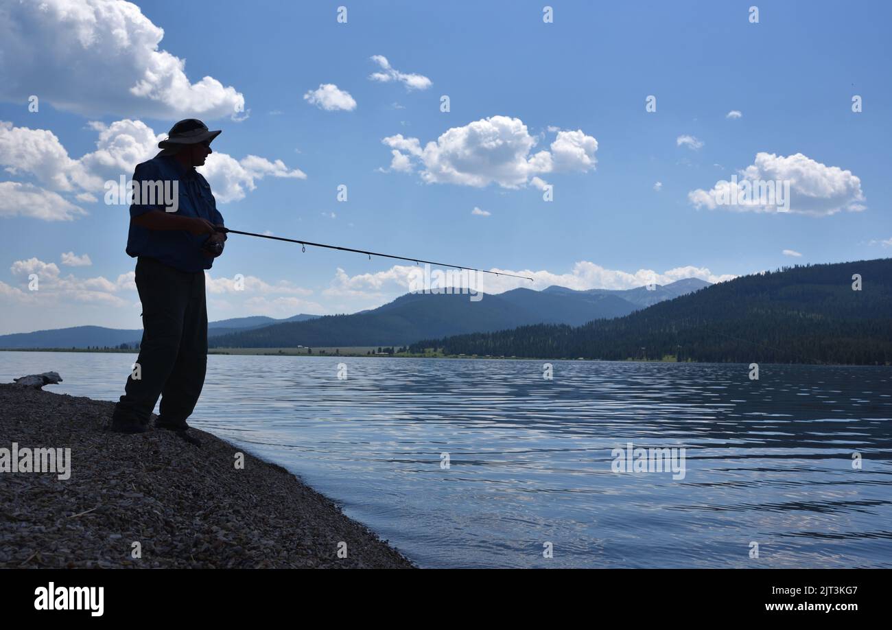 Uomo che pesca dalla riva Foto Stock