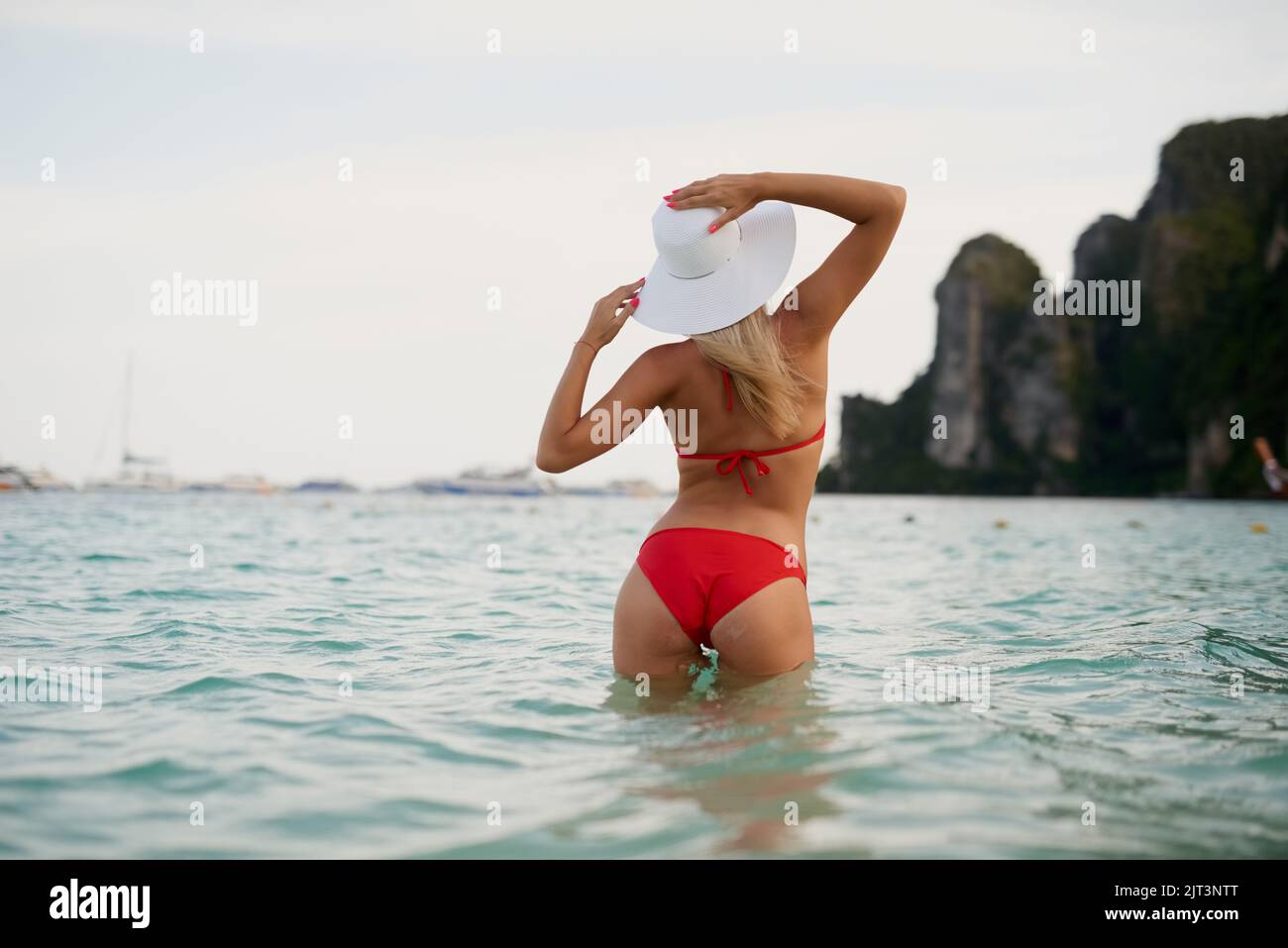 Ho perso il mio cuore al mare. Ripresa retroversa di una giovane donna in posa con il bikini in acqua. Foto Stock