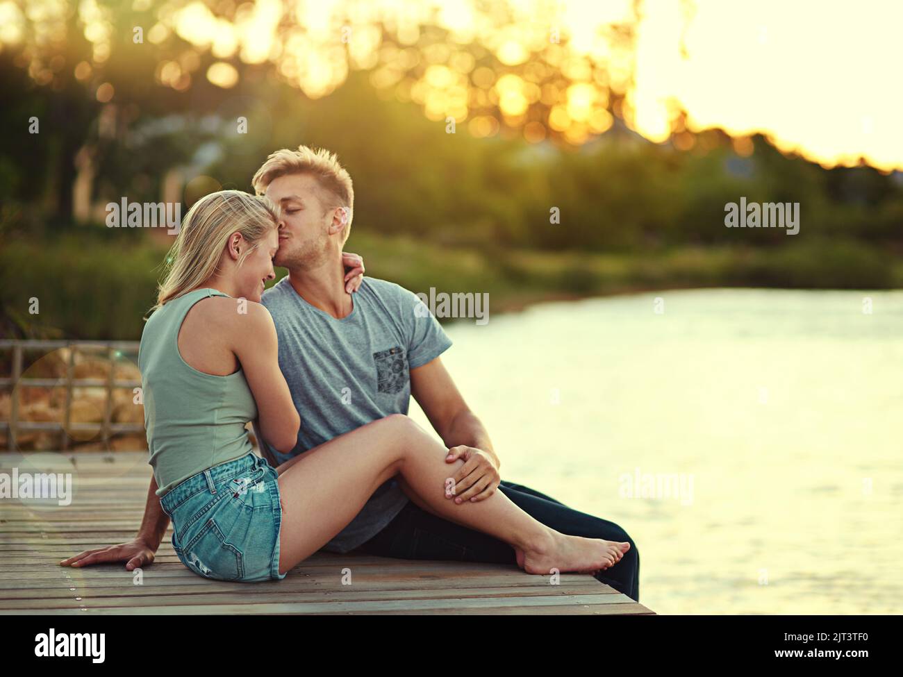 Youll essere sempre il mio per sempre. Una giovane coppia affettuosa seduta insieme ad un lago fuori. Foto Stock