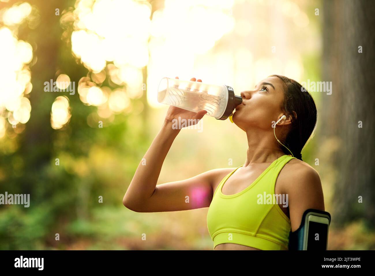 Premiati per il tuo duro lavoro. Una giovane donna che beve acqua dopo il suo allenamento. Foto Stock