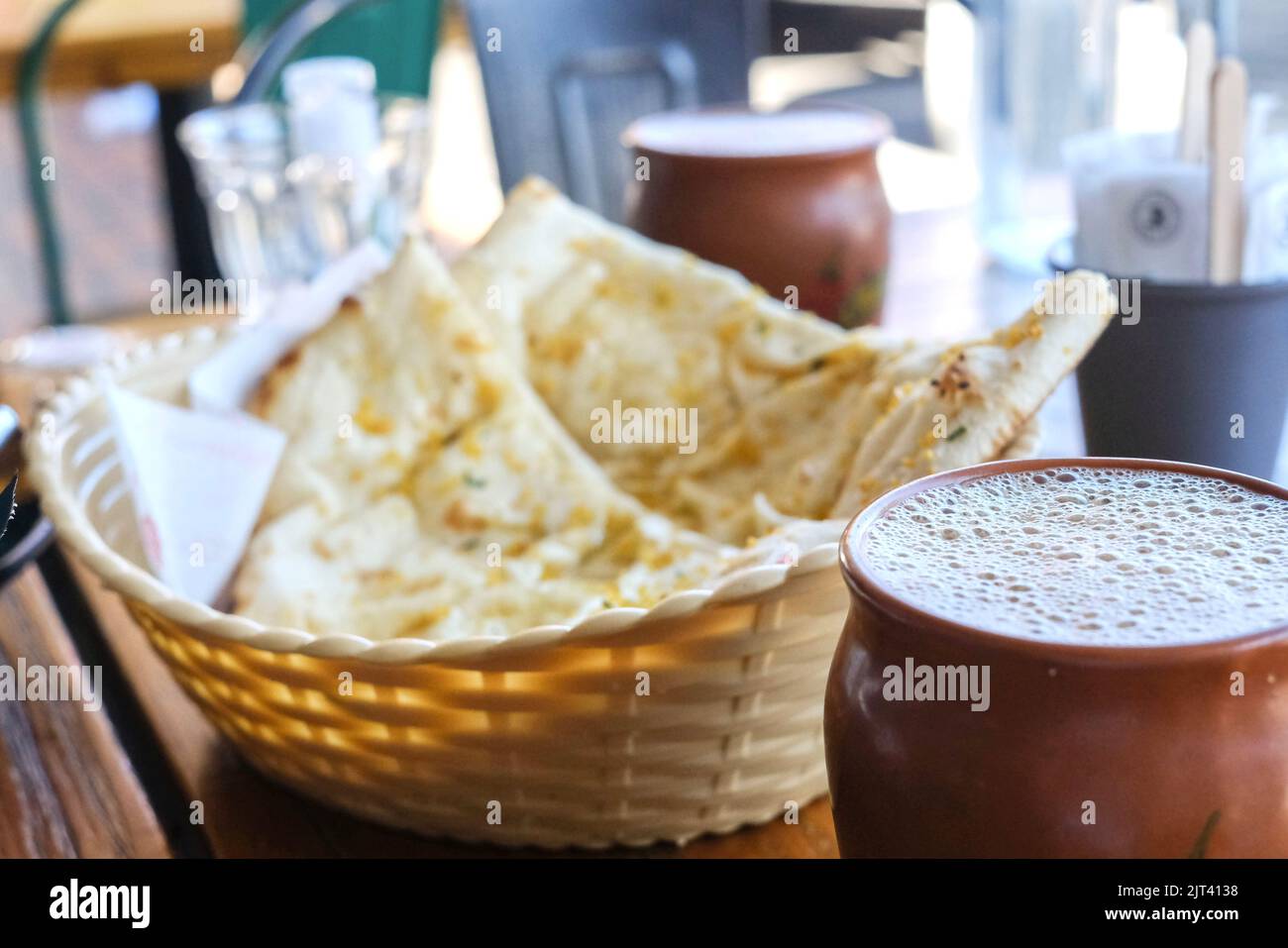 Due tazze di argilla di masala chai e un cesto di aglio naan a Chatkazz, un ristorante Street food in stile Mumbai a Harris Park - Sydney, Australia Foto Stock